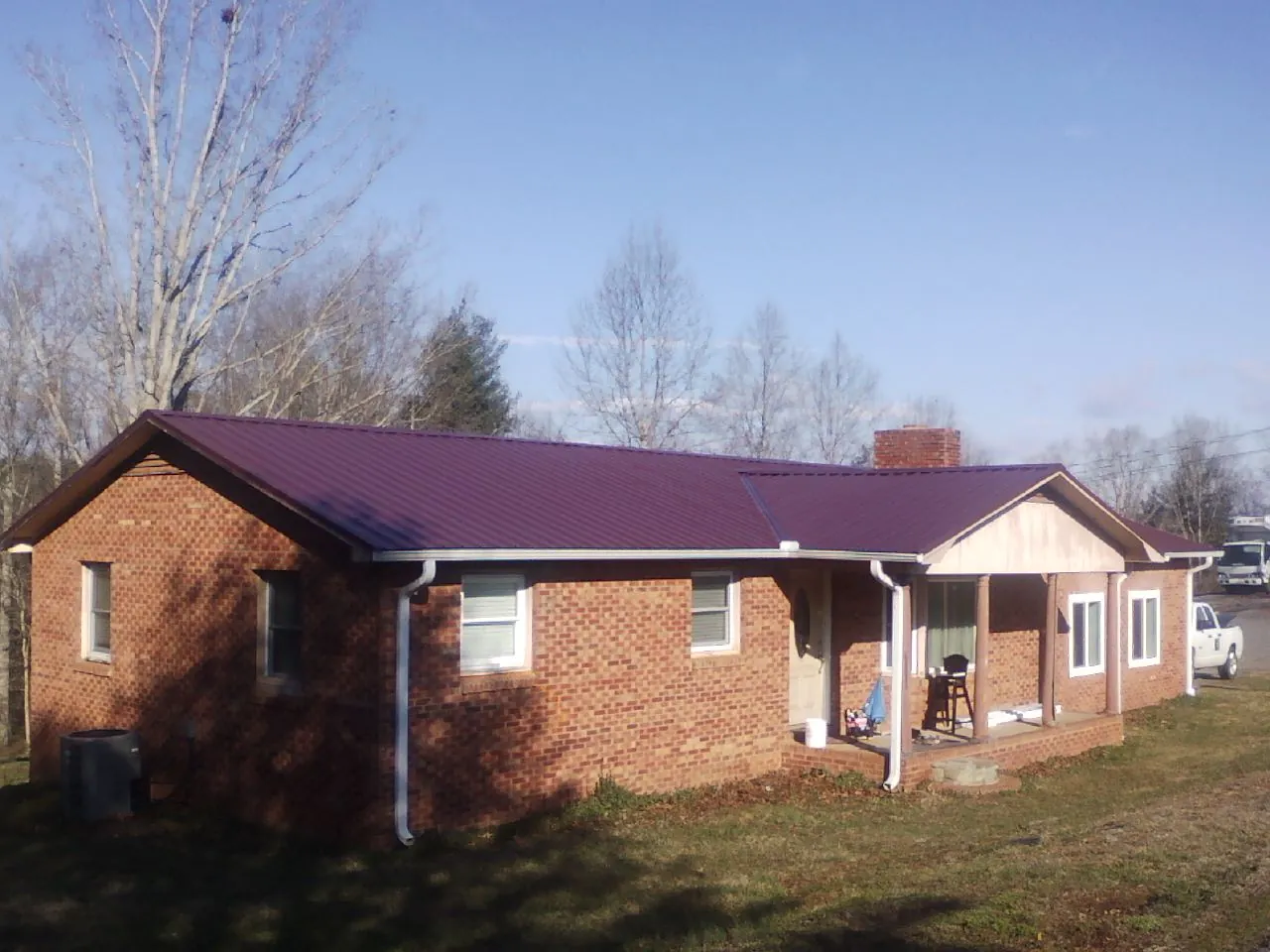 Burgundy metal roof on a brick ranch home with a new addition in Aurora